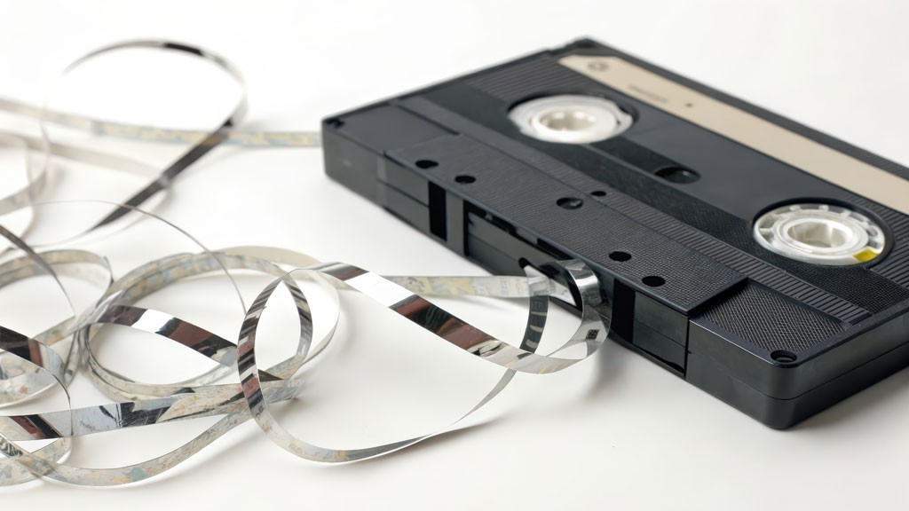 Cassette VHS ouverte montrant une bande magnétique abîmée