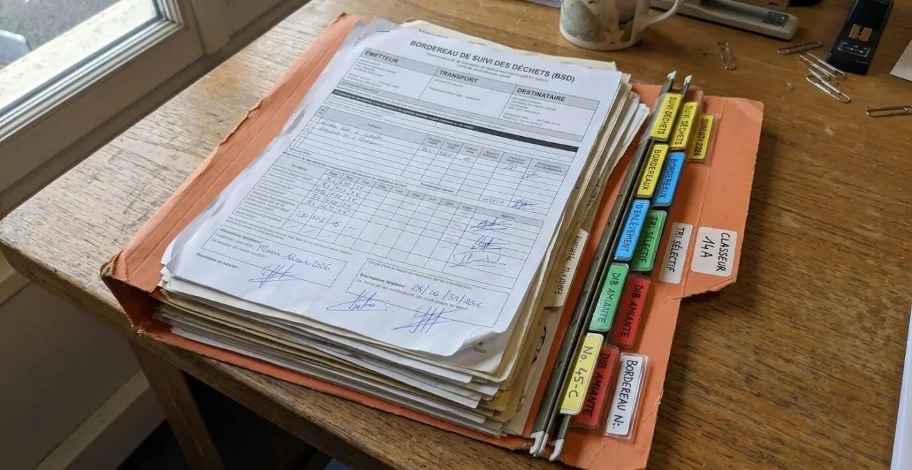 Dossier administratif contenant des bordereaux de suivi des déchets archivés et classés par date dans un classeur à onglets